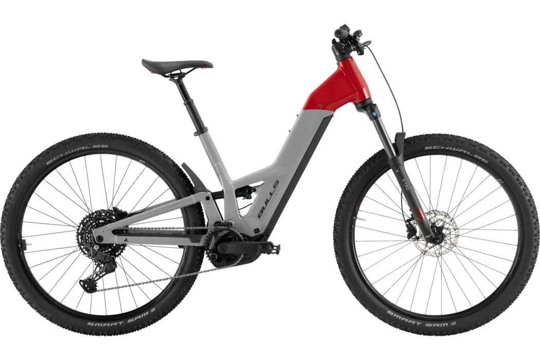 Seitenansicht eines BULLS EVO CX AM 1 2026 Wave E-Mountainbikes in Grau und Rot mit vollgefedertem Rahmen, breiten Reifen und einer absenkbarer Sattelstütze.