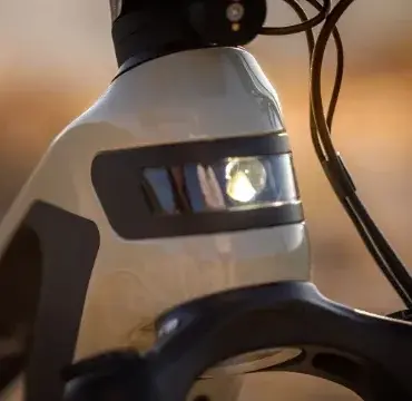 Vorderansicht des E-Mountainbikes BULLS Sonic AM 2 ABS mit Fokus auf das Steuerrohr und das integrierte Scheinwerfersystem.
