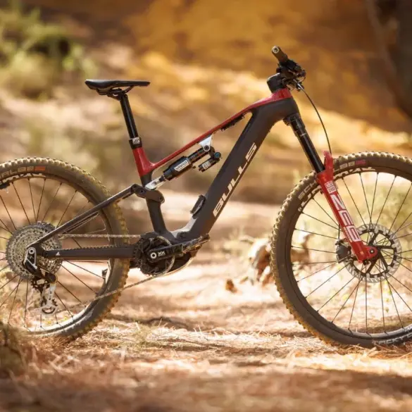 BULLS SONIC EN-R TEAM E-Enduro Mountainbike mit Vollcarbon-Rahmen und roter Federgabel, auf einem Waldweg stehend.
