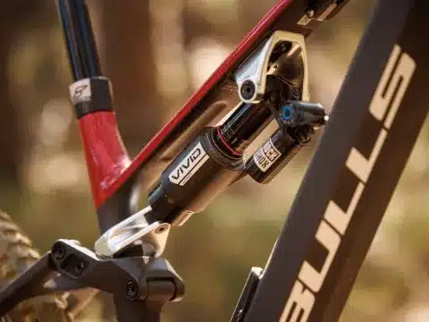 Detailaufnahme des RockShox Vivid Ultimate Dämpfers an einem E-Enduro Fahrrad der Marke Bulls mit rotem Hinterbau und schwarzem Rahmenteil.