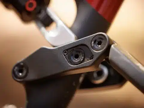 Nahaufnahme der mechanischen Verbindung am Rahmen des BULLS SONIC EN-R TEAM, welche die Anpassung der Geometrie über das Dämpferauge ermöglicht. Zu sehen sind Schrauben und Einstellmarkierungen.