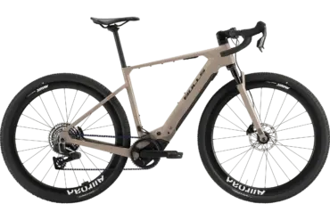 Das BULLS Trail Grinder EVO SX 2025 ist ein E-Gravelbike in einem sandfarbenen Rahmen. Es verfügt über breite Reifen mit der Aufschrift "Mavic Allroad" und "Schwalbe G-One RX", eine RockShox Federgabel und einen Bosch Performance Line SX Motor.