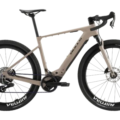 Das BULLS Trail Grinder EVO SX 2025 ist ein E-Gravelbike in einem sandfarbenen Rahmen. Es verfügt über breite Reifen mit der Aufschrift "Mavic Allroad" und "Schwalbe G-One RX", eine RockShox Federgabel und einen Bosch Performance Line SX Motor.