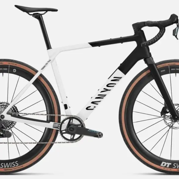 Seitenansicht eines Canyon Grail CF SLX 8 AXS Gravelbikes in den Farben Weiß und Schwarz mit braunen Reifen und DT Swiss Carbonlaufrädern.