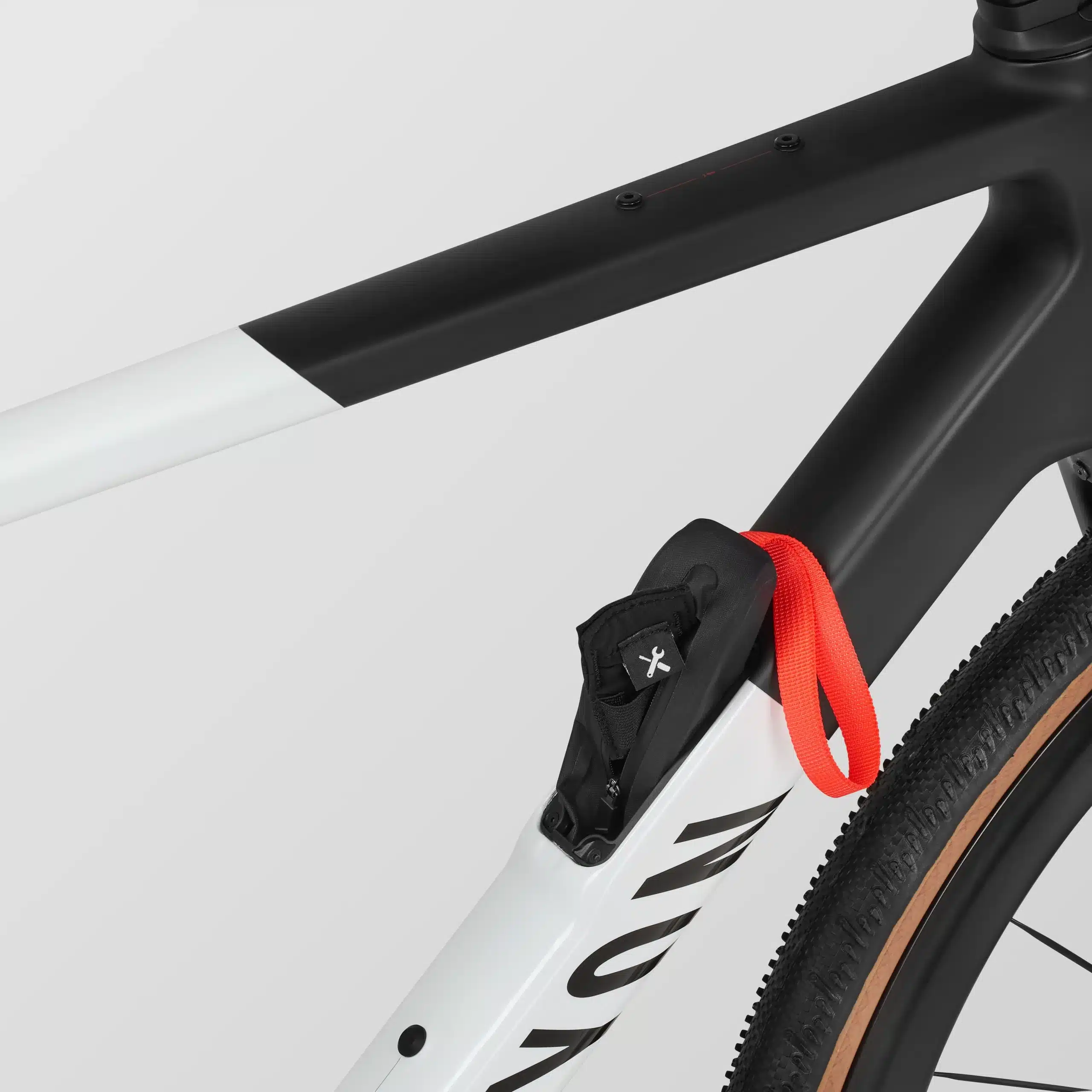 Nahaufnahme des Rahmens eines Canyon Grail CF SLX 8 Di2 Gravelbikes mit angebrachtem Staufach und rotem Gurt.