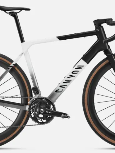 Seitenansicht eines Canyon Grail CFR Di2 Gravelbikes in weiß und schwarz mit braunen Reifen.