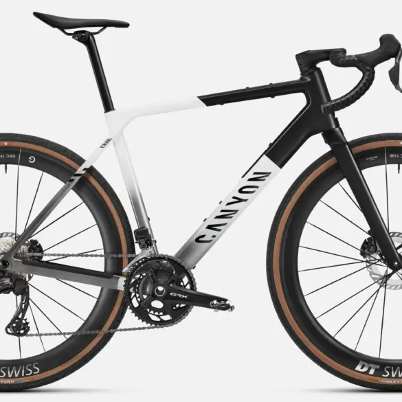 Seitenansicht eines Canyon Grail CFR Di2 Gravelbikes in weiß und schwarz mit braunen Reifen.