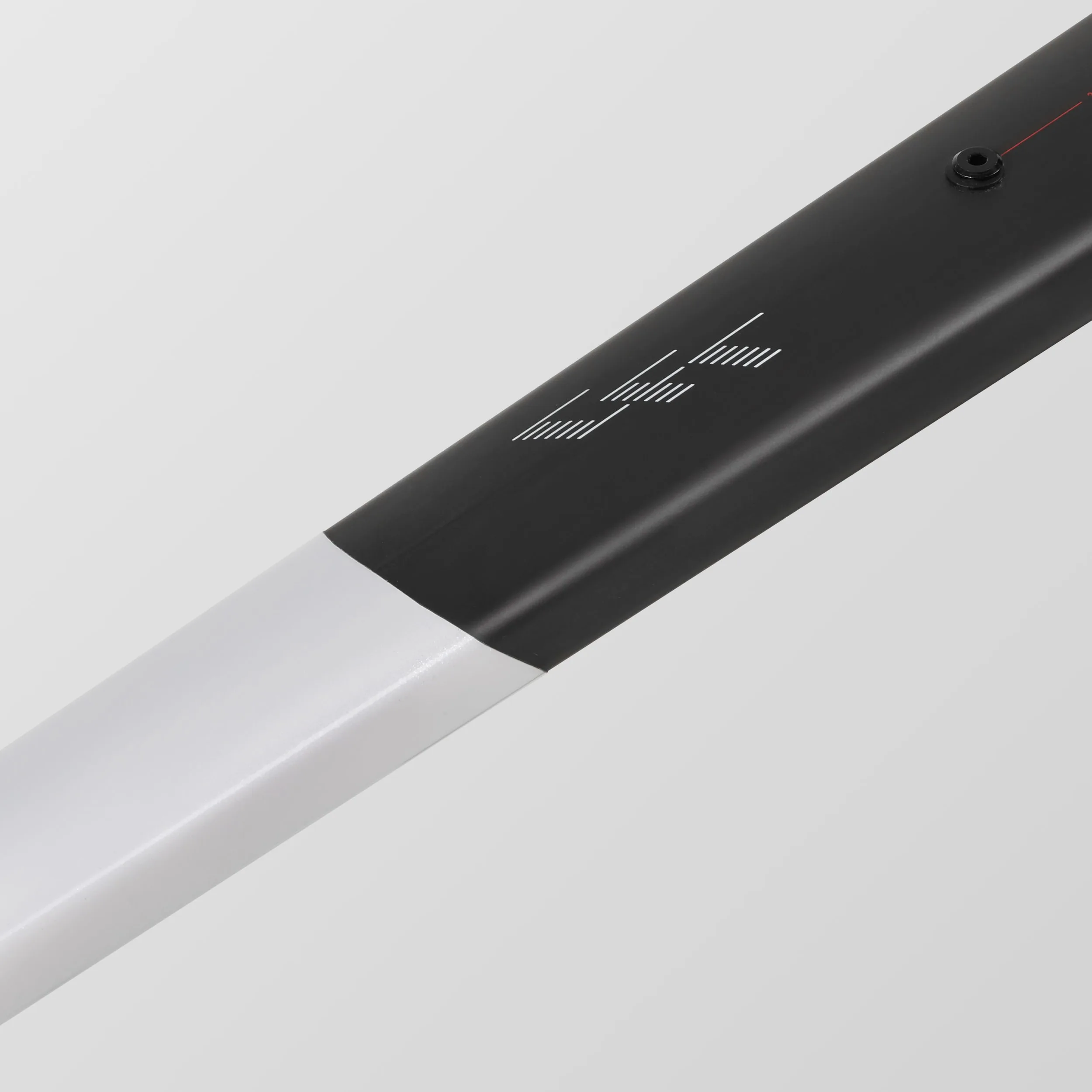 Detailaufnahme des schwarzen und weißen Carbonrahmens eines Canyon Grail CFR Di2 Fahrrads mit aufgedrucktem Logo und einer einzelnen Schraube im Rahmen.