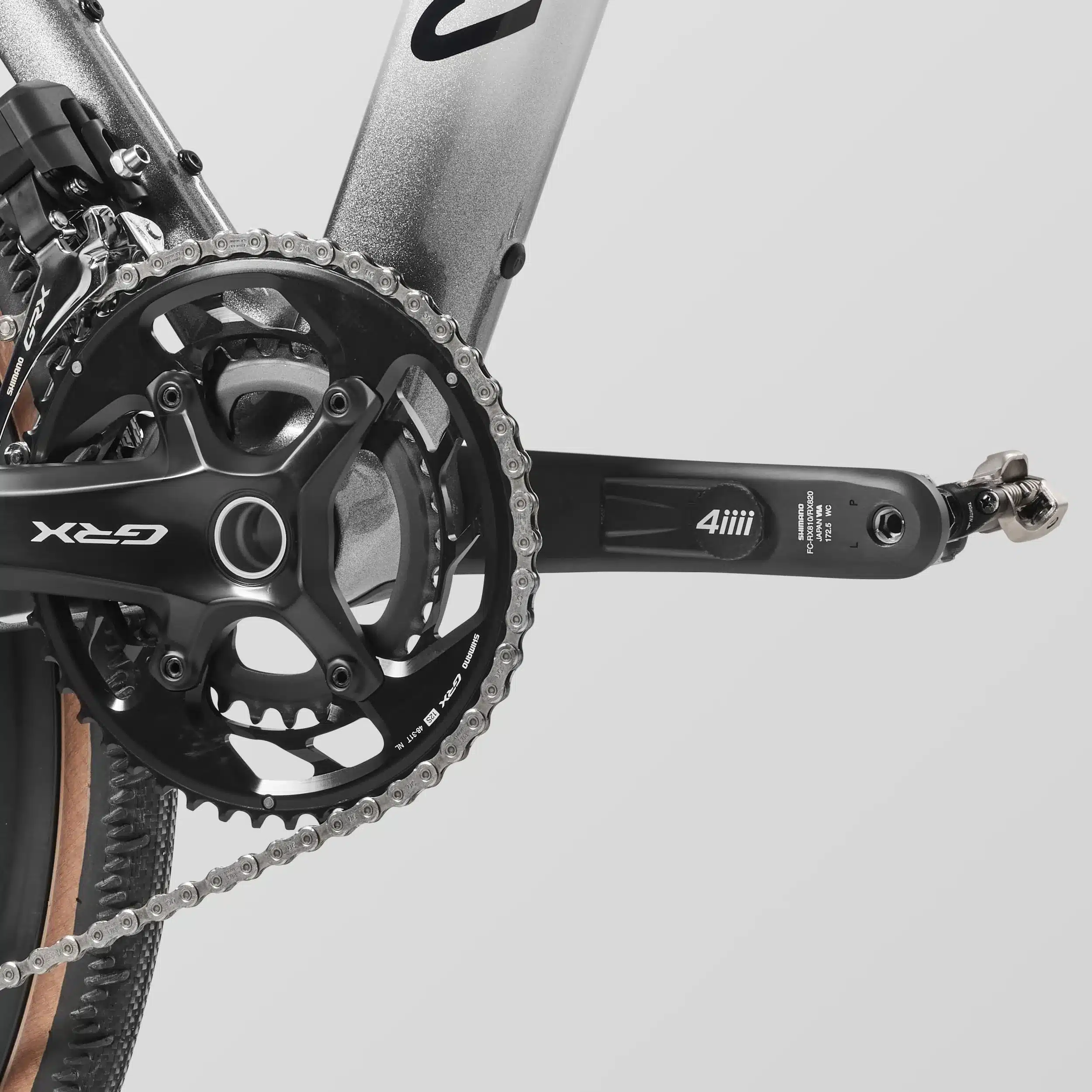 Detailaufnahme des linken Kurbelarms mit integriertem 4iiii Leistungsmesser und der Shimano GRX Kurbelgarnitur eines Canyon Grail CFR Di2 Gravelbikes.