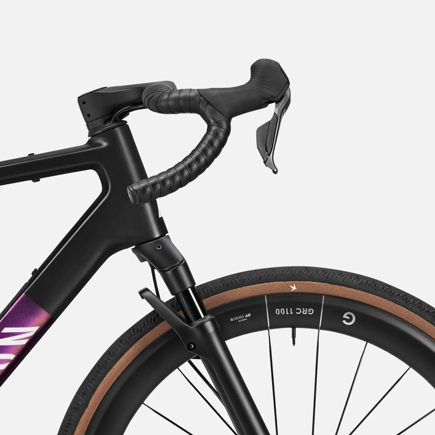 Detailaufnahme des Cockpits und des Vorderrads eines Canyon Grail CFR w/ RIFT Gravelbikes, mit Fokus auf den Lenker, die Federgabel und das Laufrad mit Reifen.