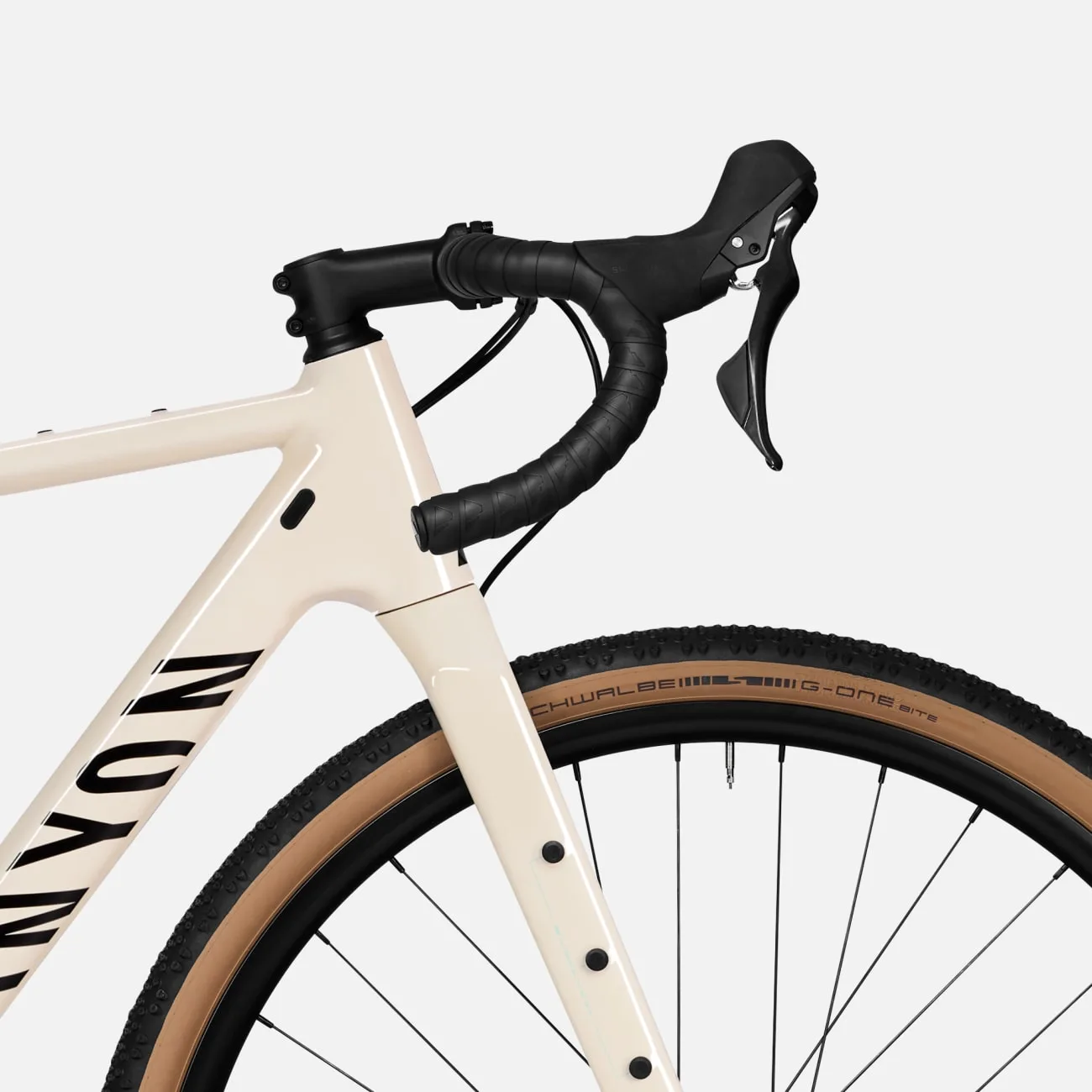 Detailansicht eines cremefarbenen Canyon Grizl 5 Gravelbikes mit schwarzen Griffen und Reifen.