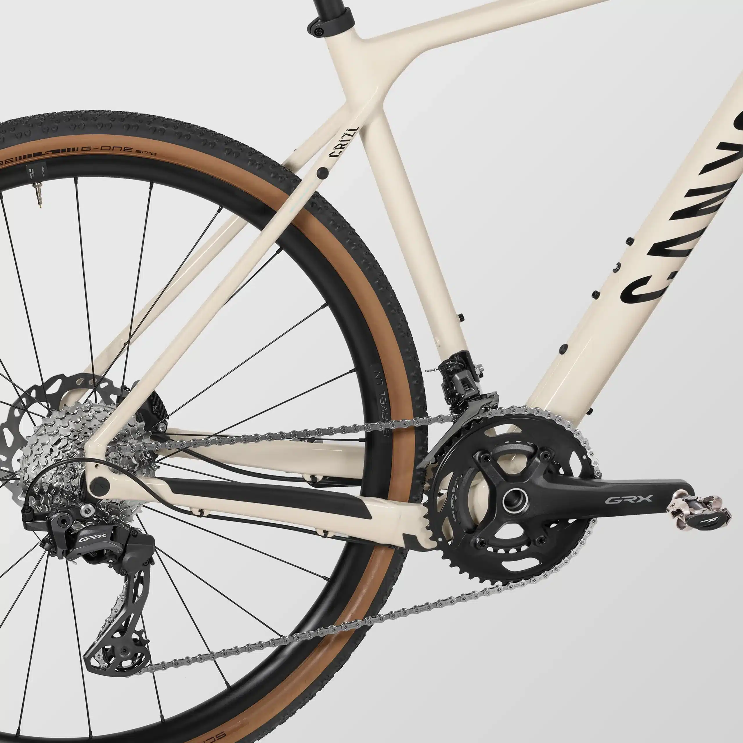 Detailansicht des Canyon Grizl 7 Gravelbikes mit Fokus auf die Shimano GRX Schaltung, die Kassette, den Aluminiumrahmen und den breiten Schwalbe G-One Reifen.