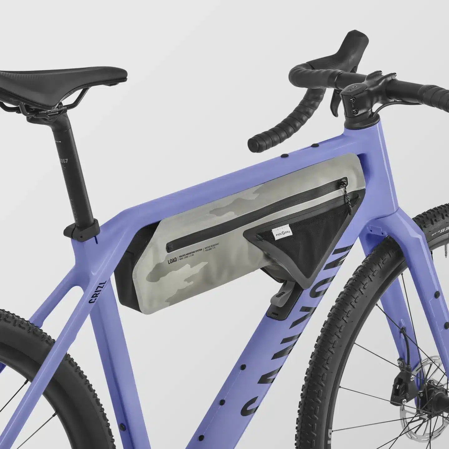 Detailaufnahme des lila Canyon Grizl CF 6 Gravelbikes mit montierter grauer Rahmentasche mit Tarnmuster.