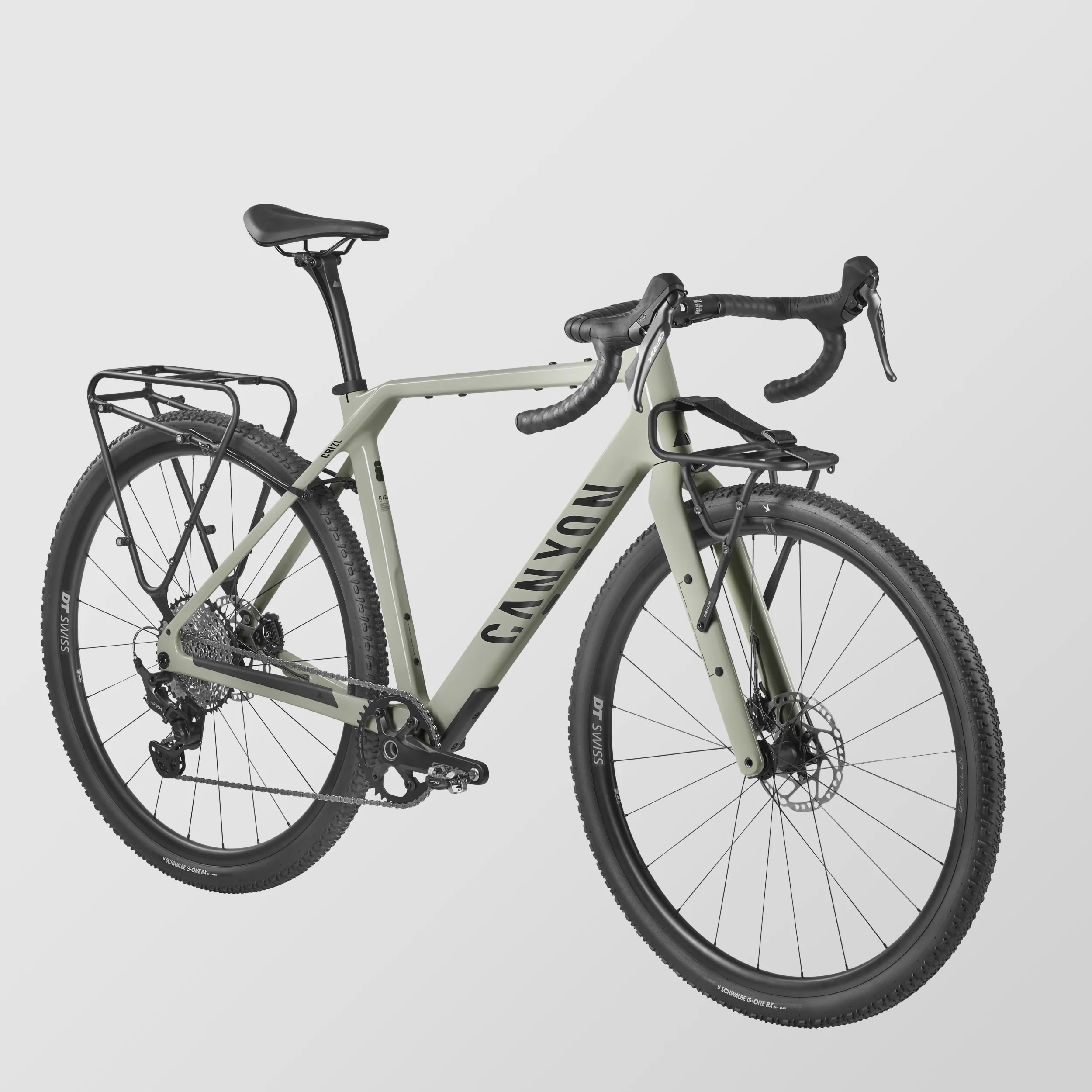 Canyon Grizl CF 7 Gravelbike in der Farbe Pineapple Gummy, ausgestattet mit DT Swiss Laufrädern, Shimano GRX Schaltung und Gepäckträgern vorne und hinten.