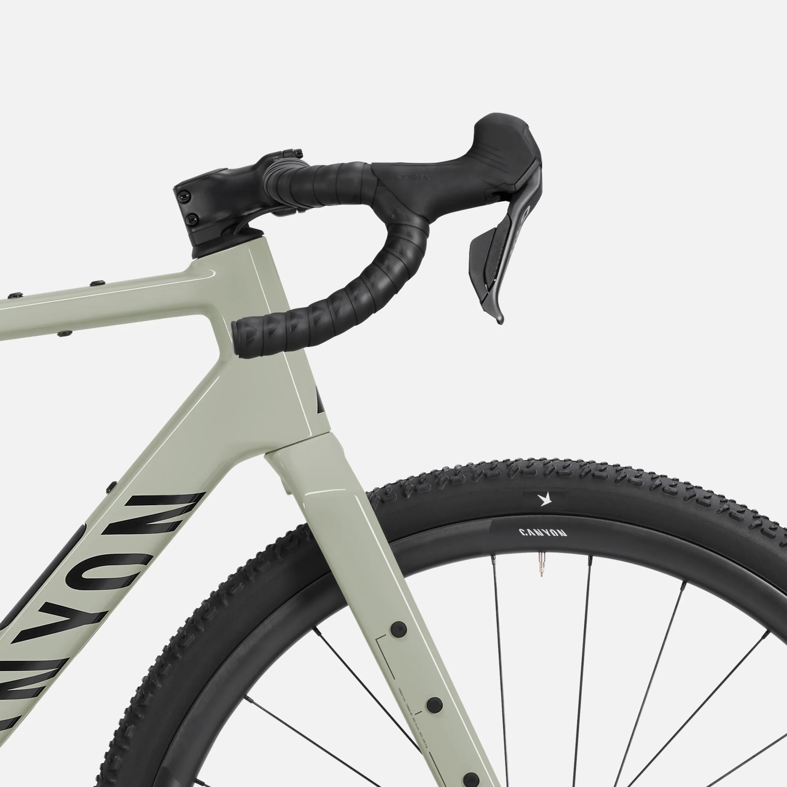 Detailaufnahme des Lenkers und des Vorderrads eines Canyon Grizl CF 8 Di2 Gravelbikes in der Farbe Pineapple Gummy.