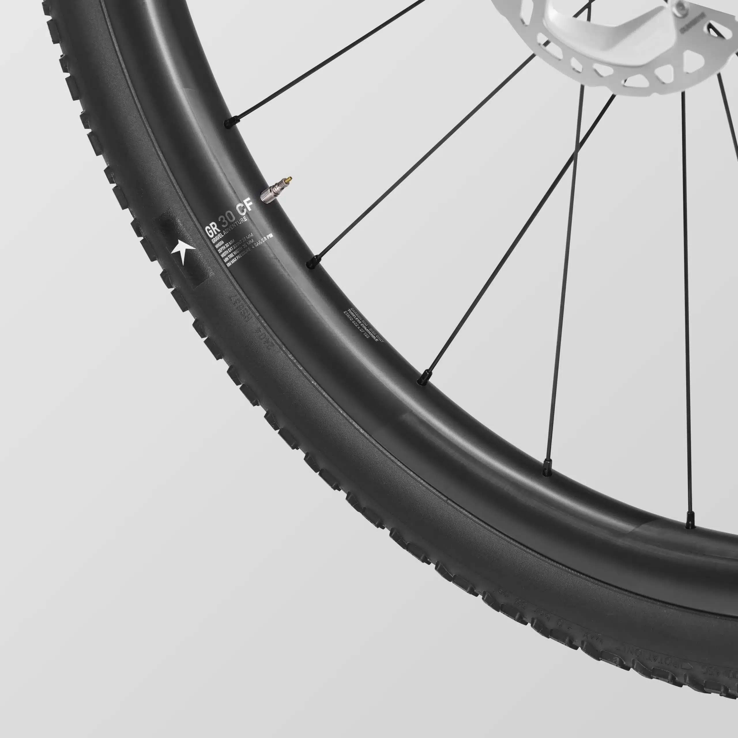 Nahaufnahme eines Fahrradrades mit schwarzem Carbonfelge, Speichen und einem breiten Gravelreifen von Schwalbe.