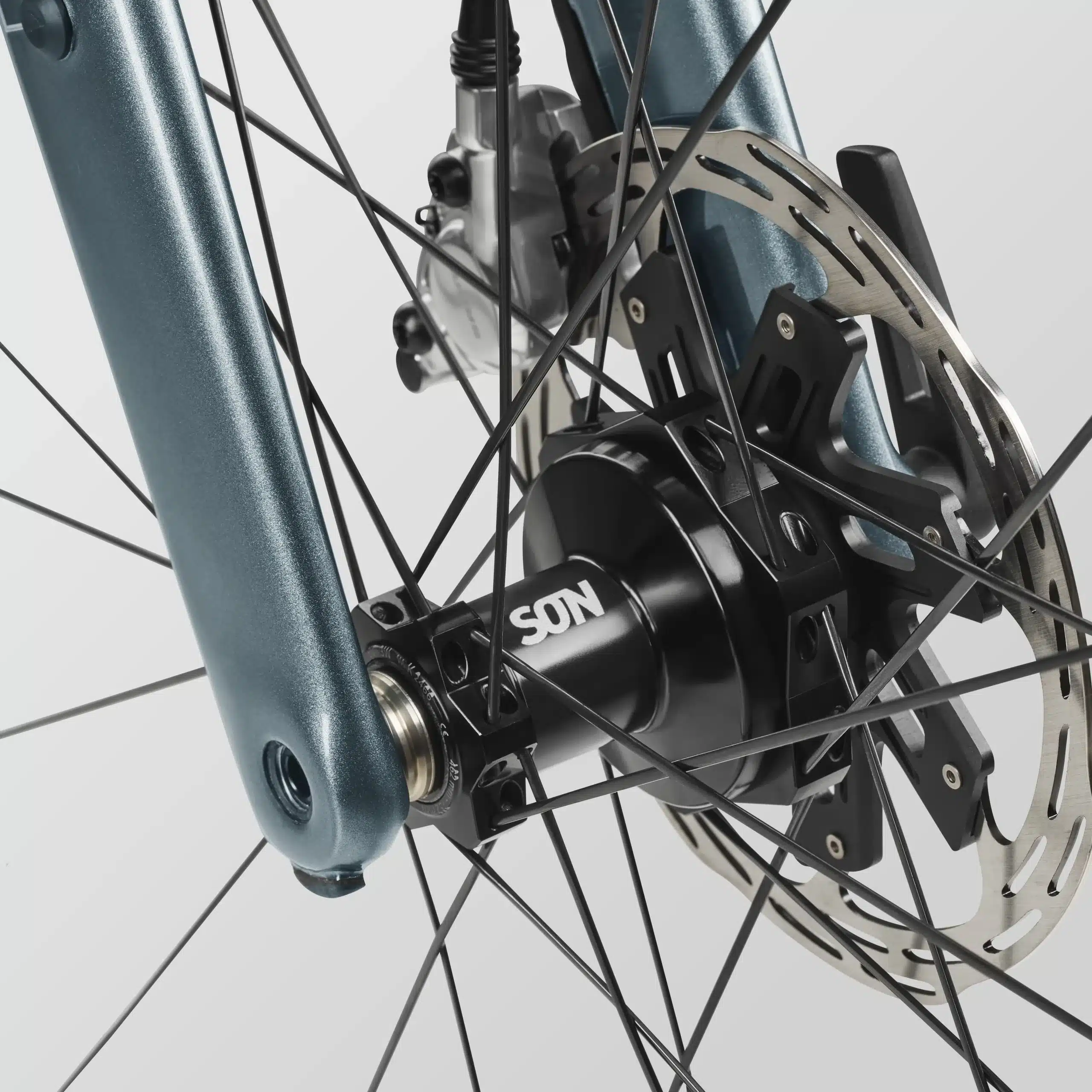 Detailaufnahme der Vorderradnabe mit SON-Logo, Scheibenbremse und einer Fahrradgabel aus Carbon, Teil des Canyon Grizl CF 9 w/ ECLIPS.