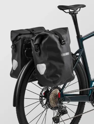 E-Gravelbike Canyon Grizl:ONfly CF 9 mit seitlichen Ortlieb-Packtaschen.