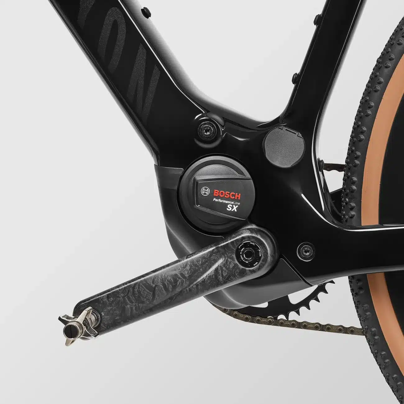 Nahaufnahme des Bosch Performance Line SX Motors und der Carbon-Kurbel eines schwarzen E-Gravelbikes.