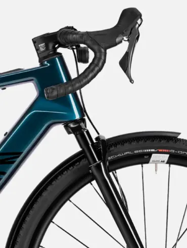 Detailansicht eines Canyon Grizl:ONfly CF Daily E-Gravelbikes, das den blauen Carbonrahmen, die Shimano Schaltgriffe, den vorderen Reifen mit Schwalbe G-One Overland Schriftzug und ein schwarzes Schutzblech zeigt.