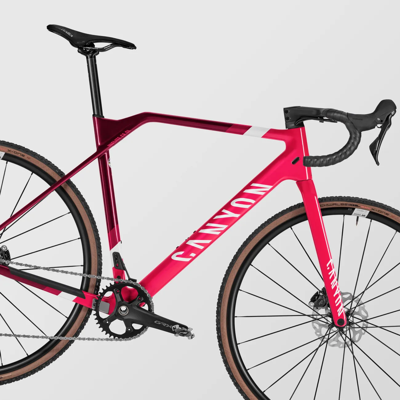 Seitenansicht eines Canyon Inflite CF SL 6 Cyclocross-Rades in leuchtendem Pink mit weißer Schrift und braunen Reifen.