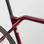 Rot lackierter Carbon-Rahmen eines Canyon Inflite CF SL 6 Fahrrads mit Nahtlos-Sitzrohr und Teilansicht eines Reifens mit Beschriftung.