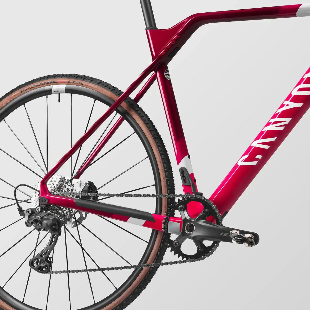 Detailansicht des roten Canyon Inflite CF SL 6 Cyclocross-Rads mit Fokus auf Hinterbau, Hinterradnabe, Kette, Kassette, Schaltwerk, Kurbel und einem Teil des Rahmens.