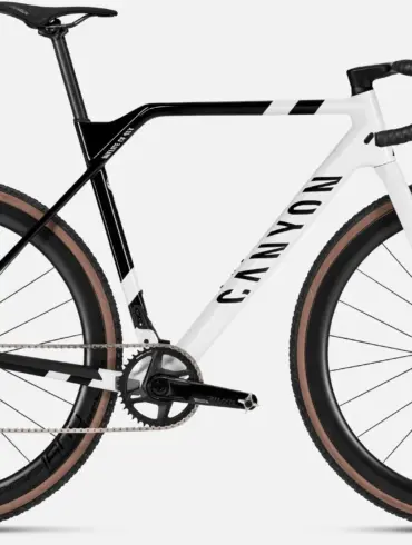 Ein Canyon Inflite CF SLX 7 Cyclocross-Rennrad mit weiß-schwarzem Rahmen und braunen Reifen.
