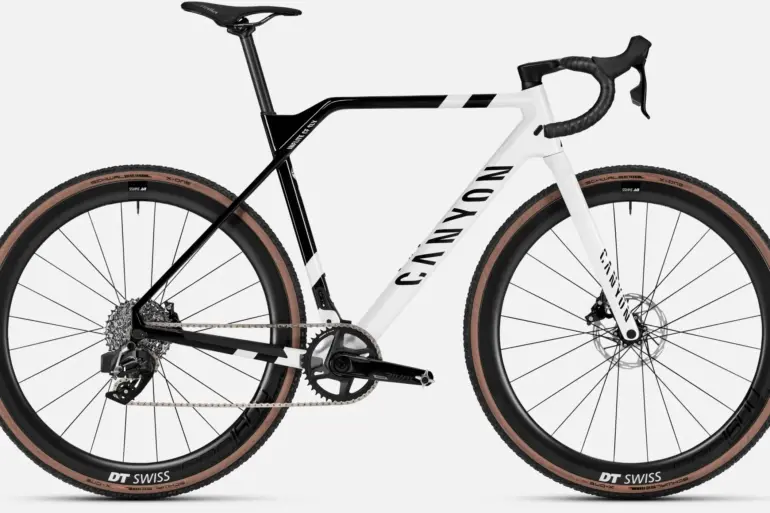 Ein Canyon Inflite CF SLX 7 Cyclocross-Rennrad mit weiß-schwarzem Rahmen und braunen Reifen.