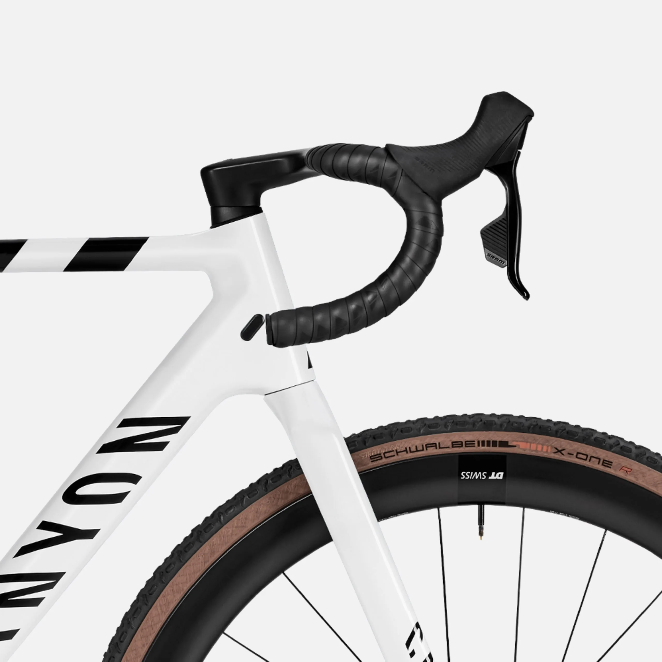 Nahaufnahme des weißen Rahmens, des schwarzen Lenkers mit Lenkerband und der SRAM Schaltbremshebel eines Canyon Inflite CF SLX 7 Cyclocross-Rads.