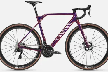 Das Canyon Inflite CFR ist ein Cyclocross-Rennrad mit einem lila-violetten Carbonrahmen, weißen Canyon-Aufschriften auf dem Unterrohr und Schriftzug 'INFLITE' am Sitzrohr. Es verfügt über eine elektronische Shimano Dura-Ace Schaltung, Rotor Aldhu Kurbel mit Leistungsmesser und DT Swiss CRC 1100 Carbon-Laufräder mit Schwalbe X-One Reifen.