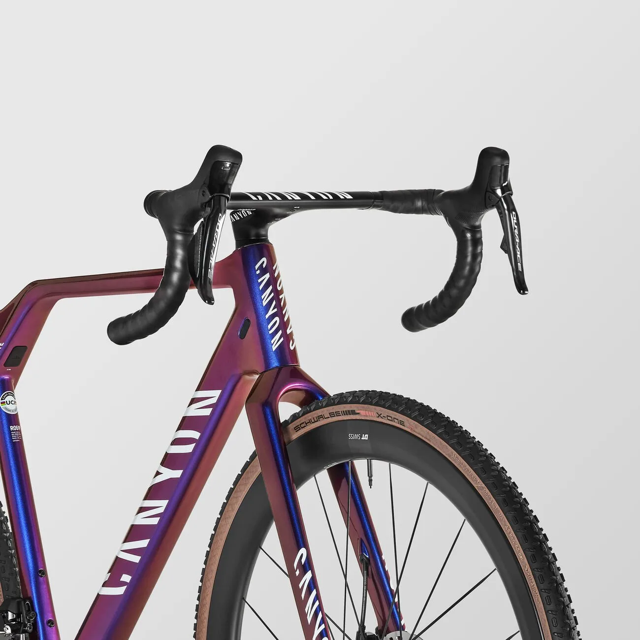 Detailaufnahme eines Canyon Inflite CFR Cyclocross-Rads mit Fokus auf den Lenker und den Vance, das Rad hat eine schillernde Lila- und Blaufärbung.
