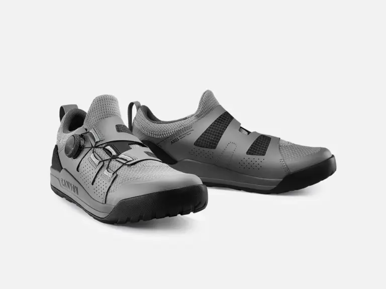 Ein Paar graue Canyon Scampr Trail Cycling Shoes mit Klickpedal-System, Ansicht von vorne links.