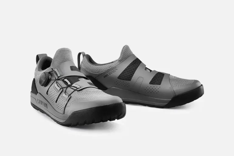 Ein Paar graue Canyon Scampr Trail Cycling Shoes mit Klickpedal-System, Ansicht von vorne links.