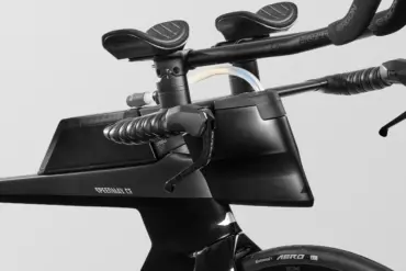 Nahaufnahme des schwarzen Canyon Speedmax CF 7 Di2 Race Triathlonrads, Fokus auf das aerodynamische Cockpit mit integrierter Trinkflasche, Lenkerhörnchen und elektronischen Schalthebeln.