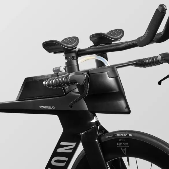 Nahaufnahme des schwarzen Canyon Speedmax CF 7 Di2 Race Triathlonrads, Fokus auf das aerodynamische Cockpit mit integrierter Trinkflasche, Lenkerhörnchen und elektronischen Schalthebeln.