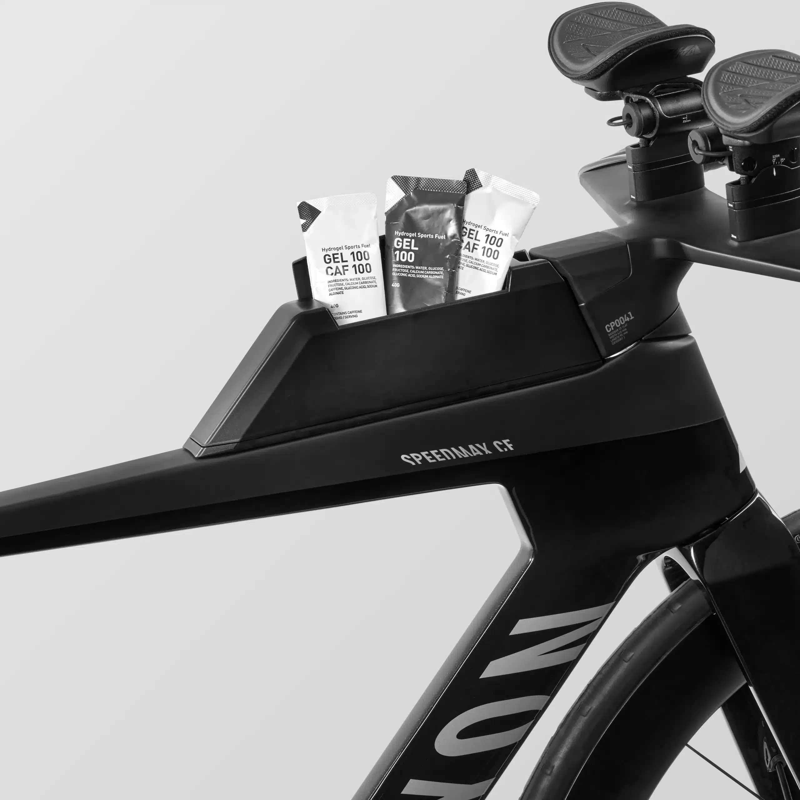 Detailaufnahme eines schwarzen Canyon Speedmax CF 7 Di2 Race Triathlonrads, das ein integriertes Staufach mit drei Energie-Gels zeigt.