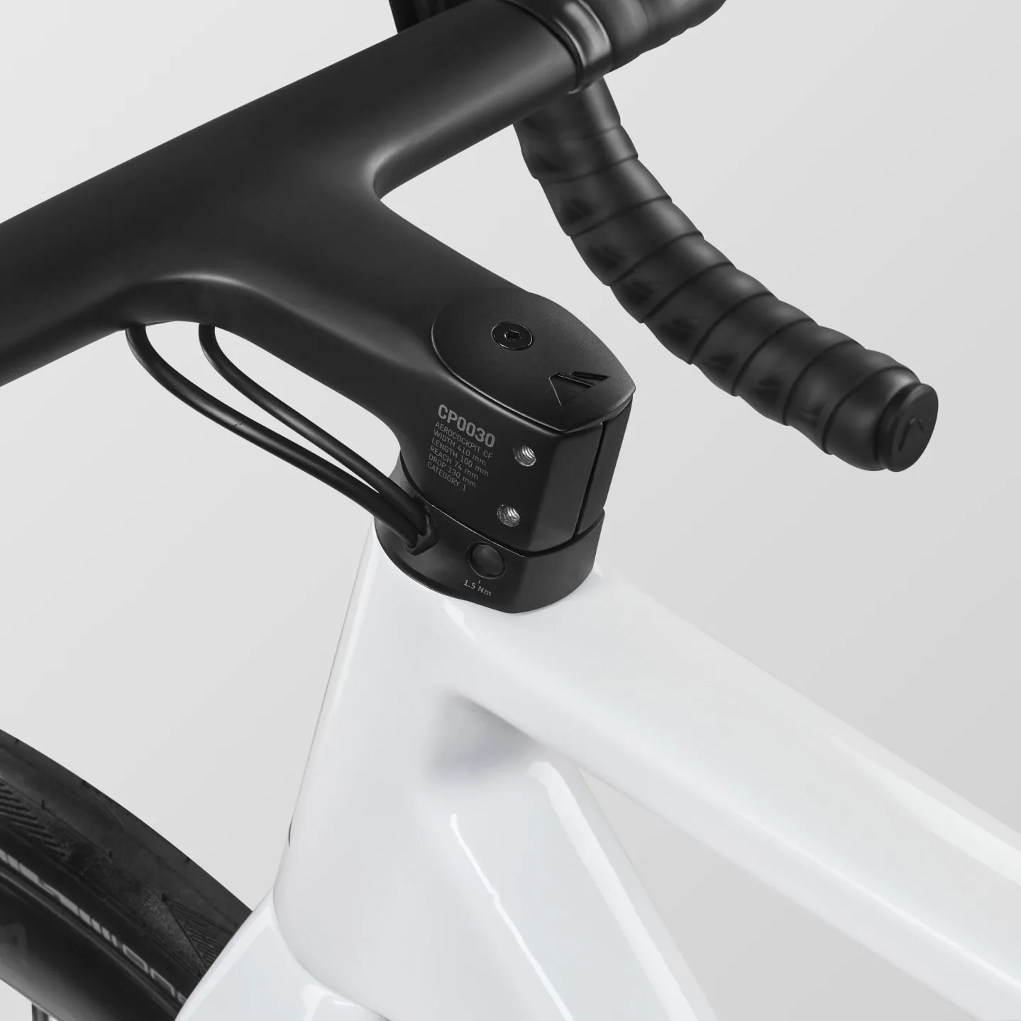 Detailansicht des weißen Canyon Ultimate CF 7 A.50 Rennradrahmens mit schwarzem Carbon-Cockpit und Lenker.