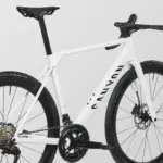 Detailansicht eines weißen Canyon Ultimate CF 7 A.50 Rennrads, Fokus auf den Carbonrahmen, die Kurbelgarnitur und das Hinterrad.