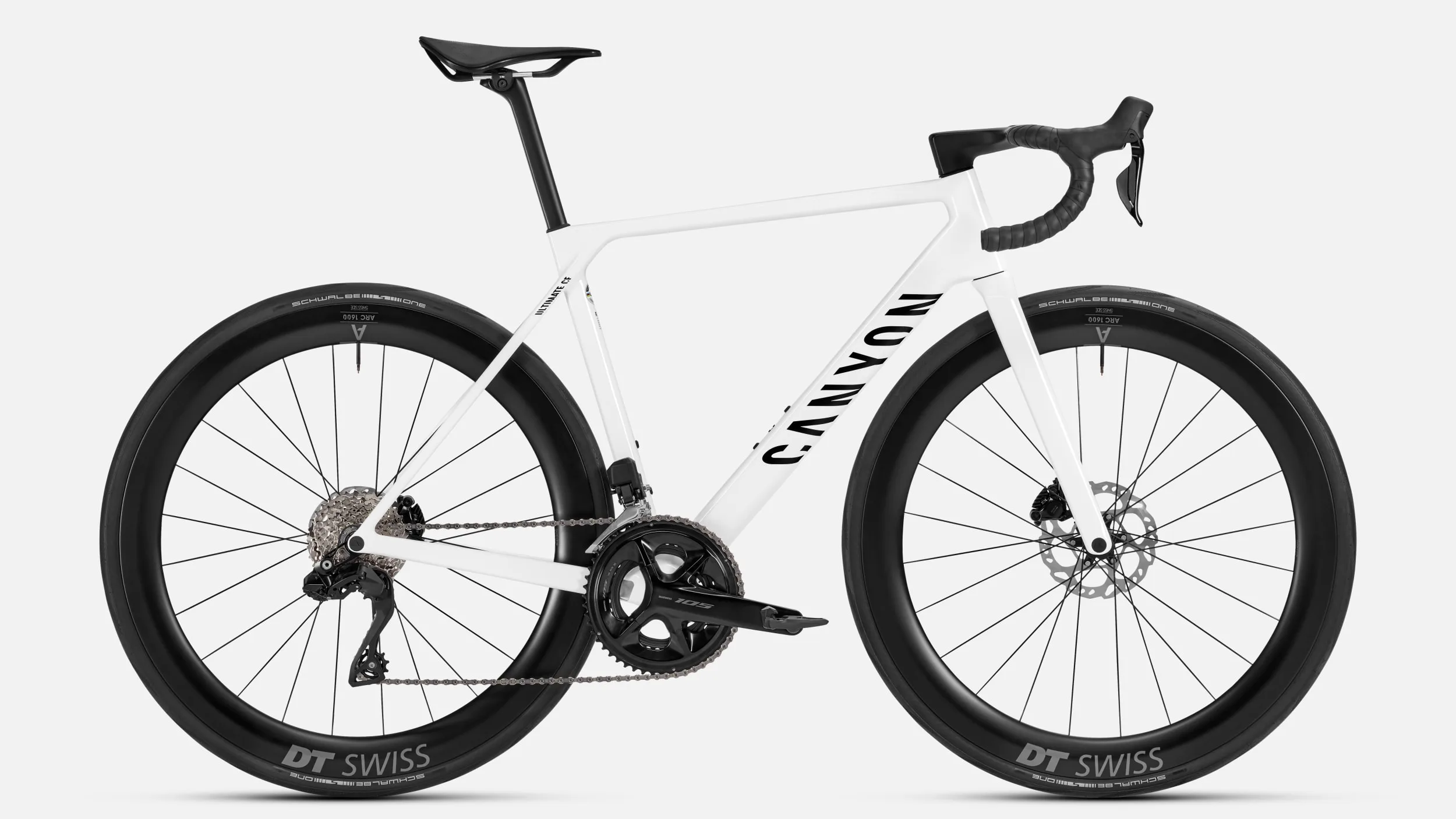 Seitenansicht eines weißen Canyon Ultimate CF 7 Di2 Aero Rennrads mit schwarzen Anbauteilen und DT Swiss Laufrädern.