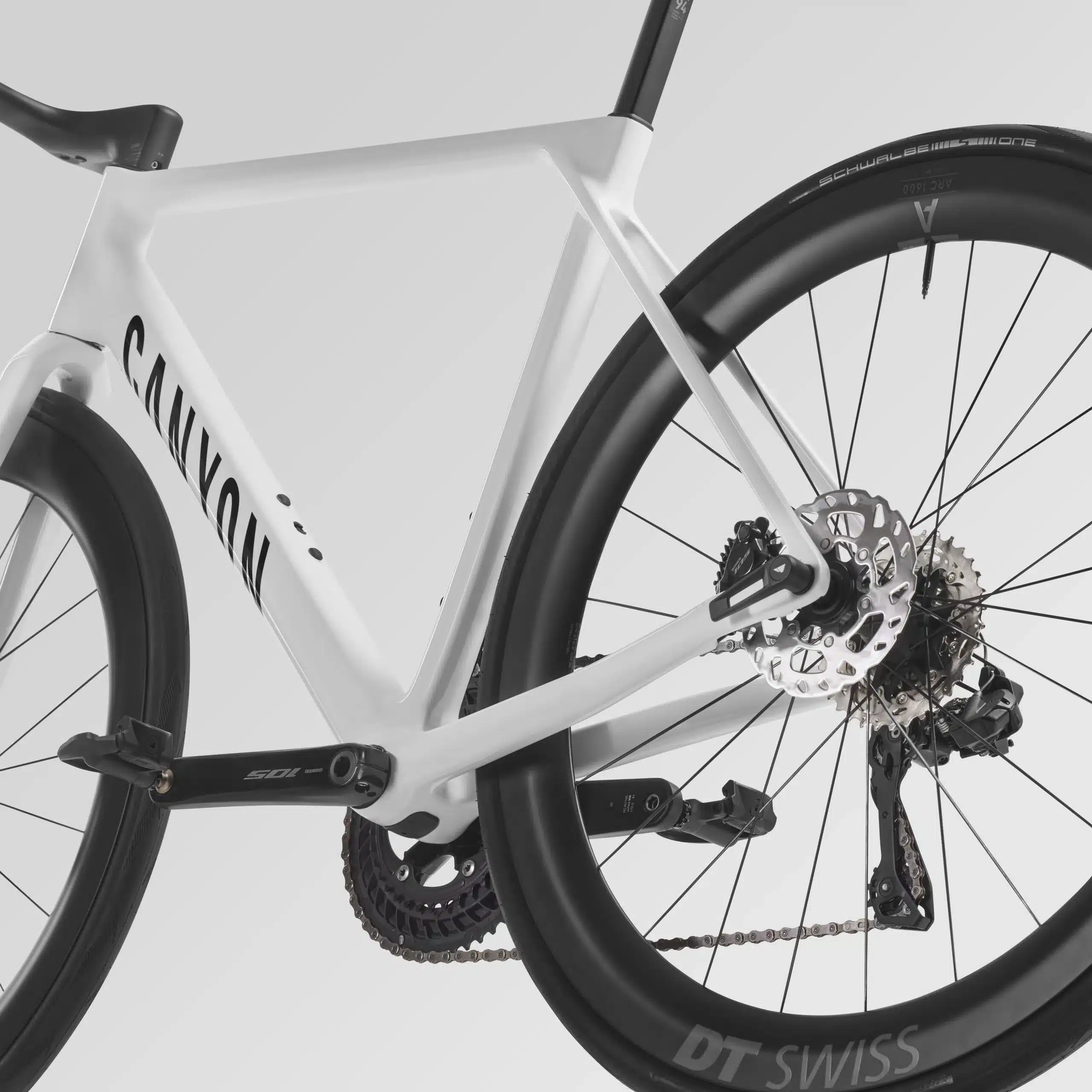 Nahaufnahme der Hinterradbremse und des Schaltwerks eines weißen Canyon Ultimate CF 7 Di2 AERO Rennrads mit DT Swiss Carbonlaufrädern.