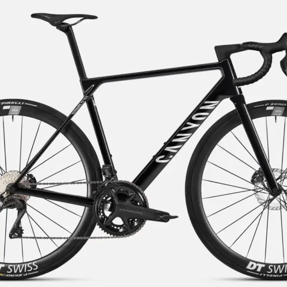 Seitenansicht eines schwarzen Canyon Ultimate CF SLX 8 Di2 Rennrads mit DT Swiss Carbon-Laufrädern und Shimano Ultegra Di2 Schaltung auf grauem Hintergrund.