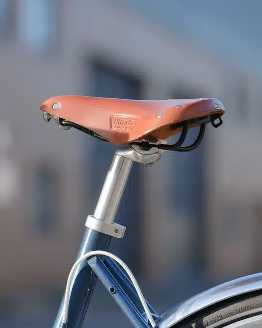Nahaufnahme eines braunen Leder-Fahrradsattels der Marke Brooks auf einem Aluminium-Sattelrohr.