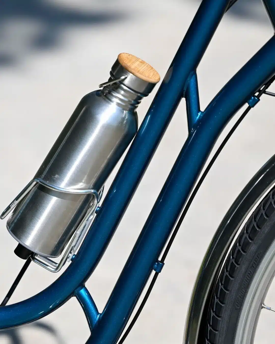 Nahaufnahme eines blauen Capri Berlin Electric 3 Fahrradrahmens, an dem ein silberner Flaschenakku mit Holzdeckel befestigt ist.