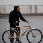 Orangefarbenes Capri Metz E-Bike mit einem Mann, der daneben steht.