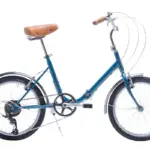 Seitenansicht eines blauen Capri Vita Falt-E-Bikes mit braunem Sattel und braunen Lenkergriffen, freigestellt vor weißem Hintergrund.