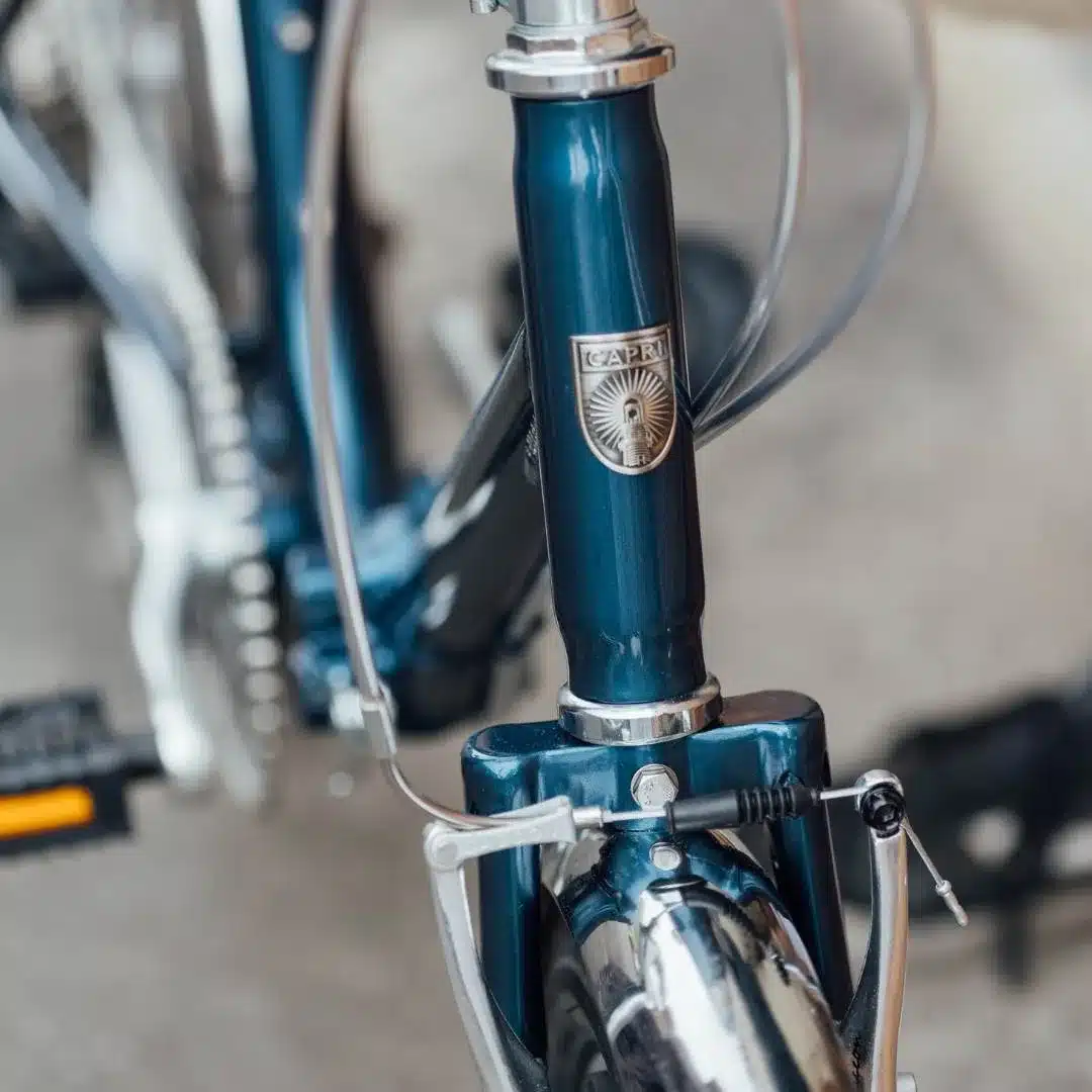 Detailaufnahme eines blauen Capri Vita Falt-E-Bikes, Fokus auf den Steuersatz mit dem Markenschriftzug.