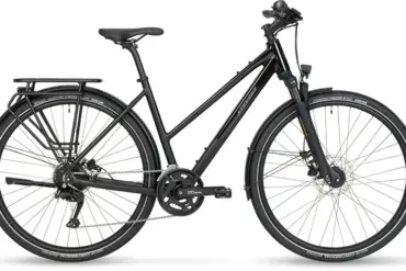 Ein schwarzes Aviolo 6.1 LT Trekkingrad von Stevens mit Gepäckträger, Schutzblechen und Lichtanlage, stehend vor weißem Hintergrund.
