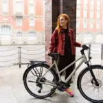 Frau neben einem Stevens Aviolo 7.1 LT Trekkingrad mit Frau, das für den täglichen Einsatz und längere Strecken konzipiert ist.