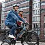 Mann und Frau fahren Fahrrad, beide tragen Helme.